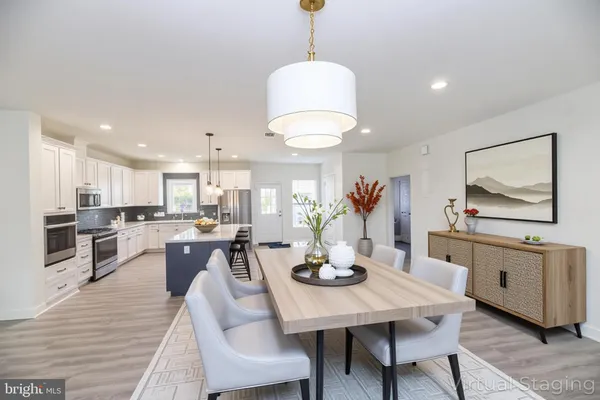 a view of a dining room and livingroom with furniture wooden floor a chandelier