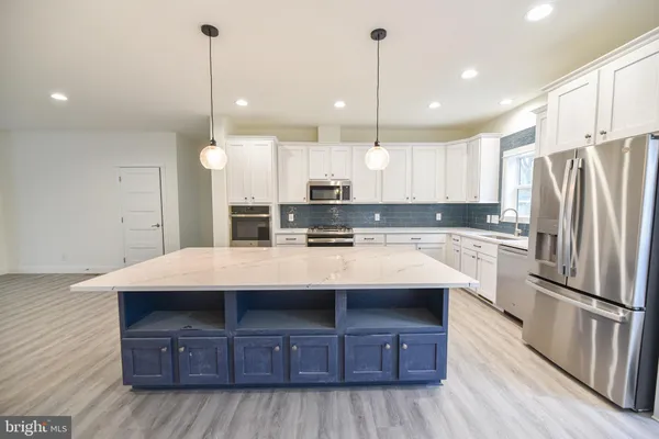 a kitchen with kitchen island wooden cabinets and stainless steel appliances