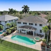 a aerial view of a house with table and chairs under an umbrella