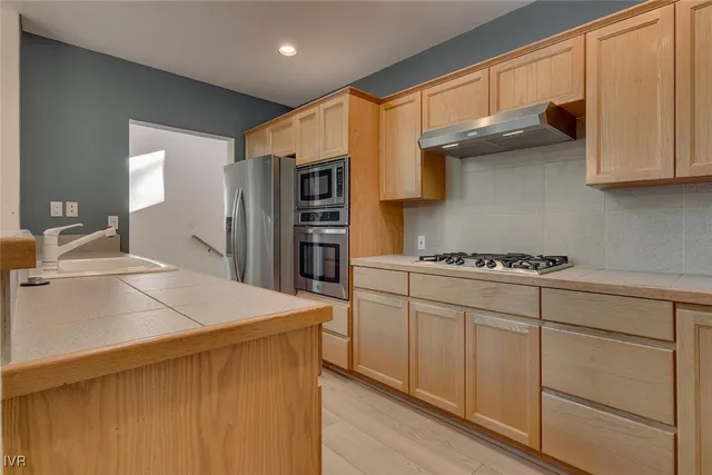 a kitchen with stainless steel appliances a sink and a refrigerator