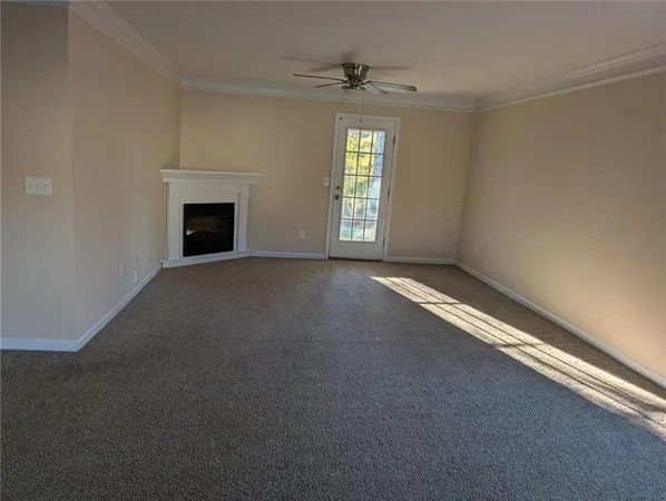 an empty room with windows and fireplace