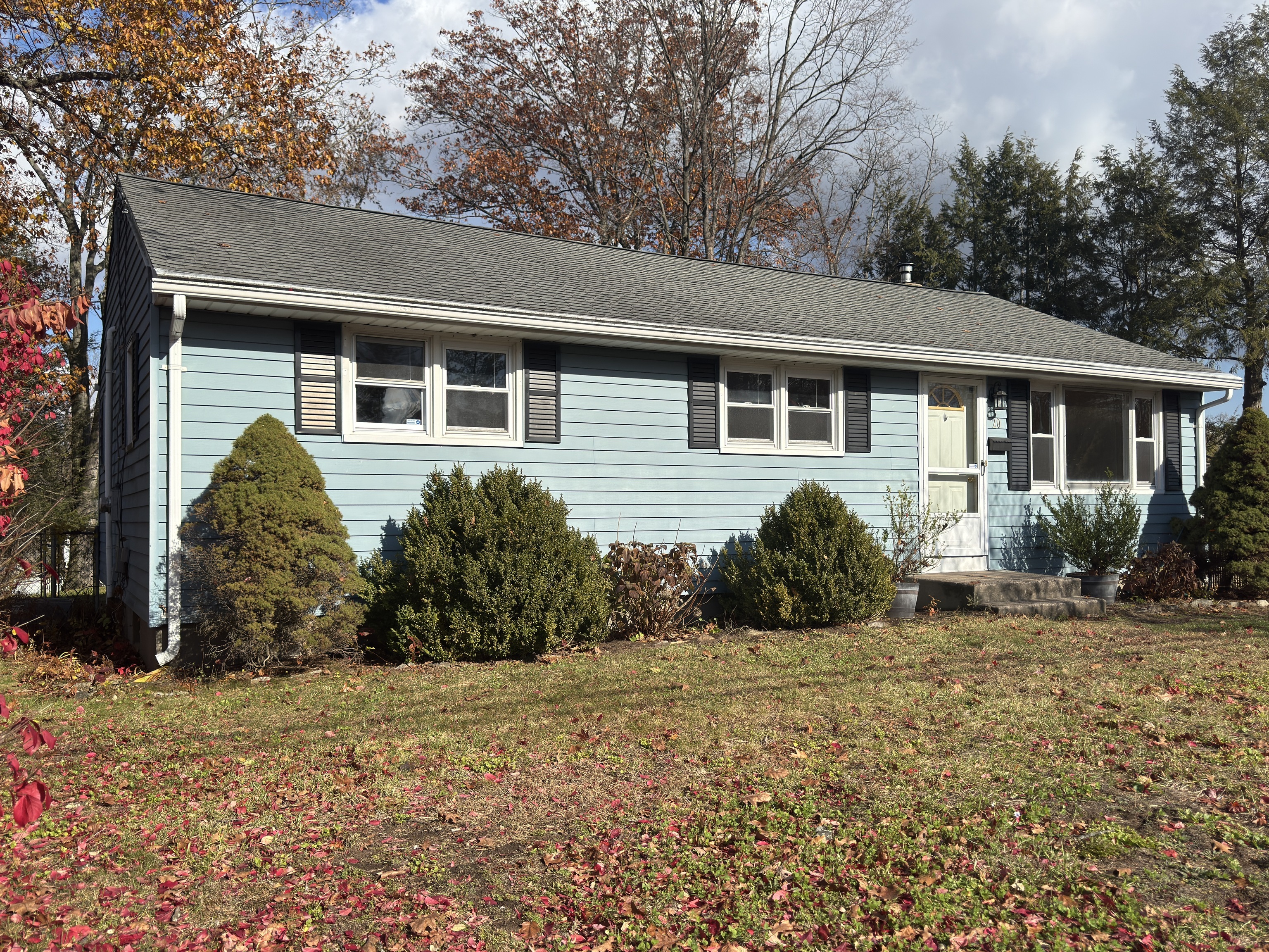a front view of house with yard and trees around