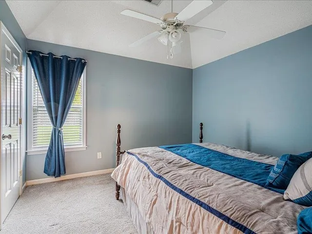 a bedroom with a bed dresser and a window