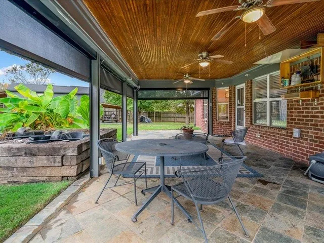 a backyard of a house with potted plants and wooden fence