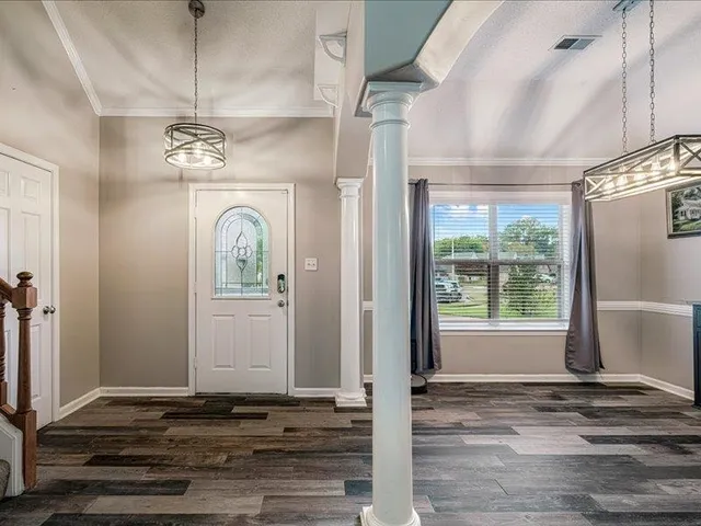 a view of a hallway with wooden floor and chandelier