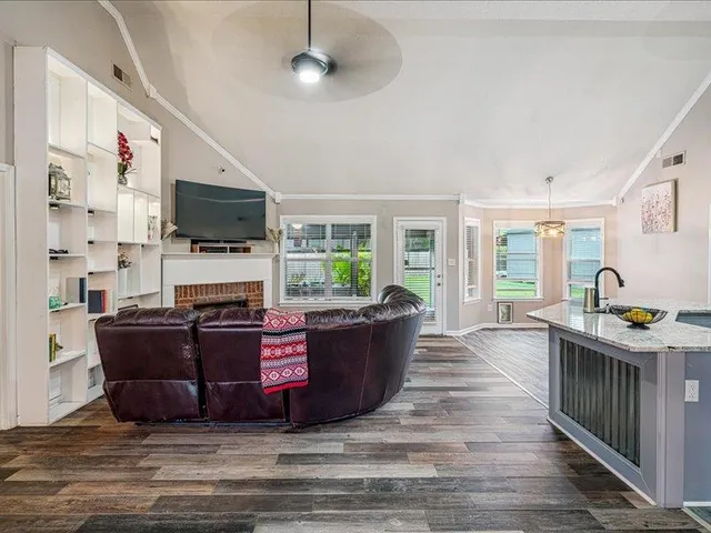 a living room with furniture a flat screen tv and a fireplace