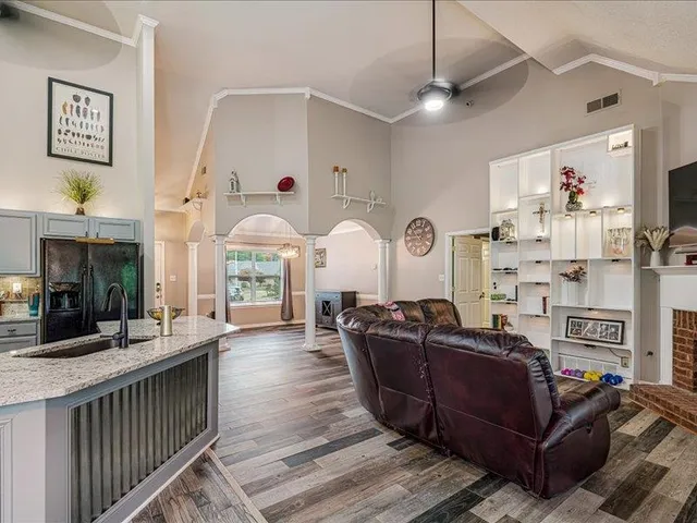 a living room with furniture a fireplace and a chandelier
