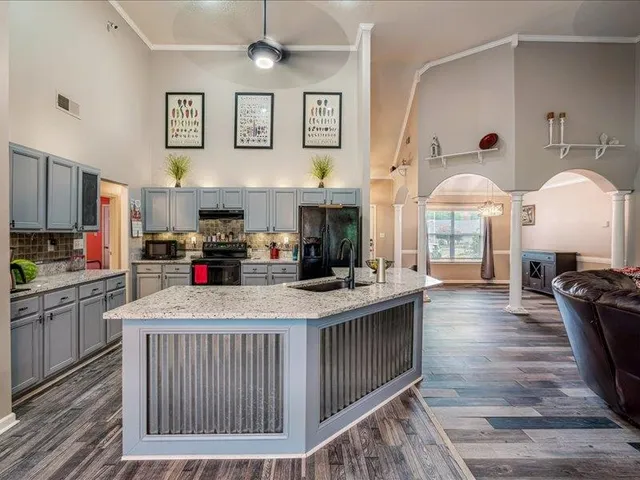 a kitchen with stainless steel appliances granite countertop a stove a sink and a refrigerator