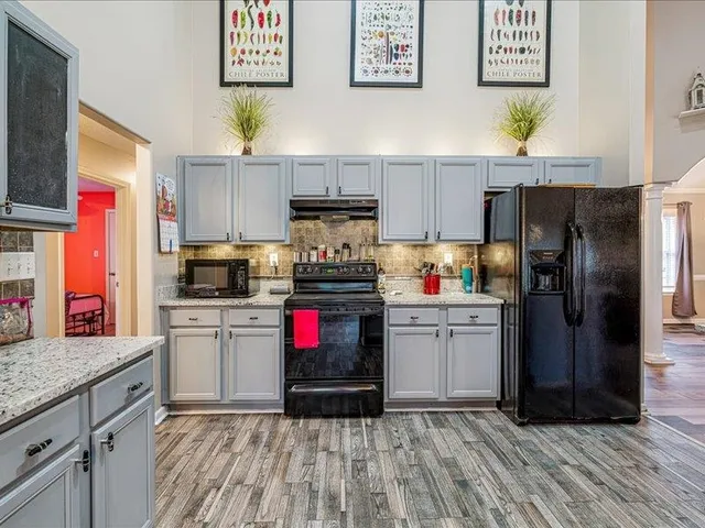 a kitchen with a refrigerator and a stove top oven