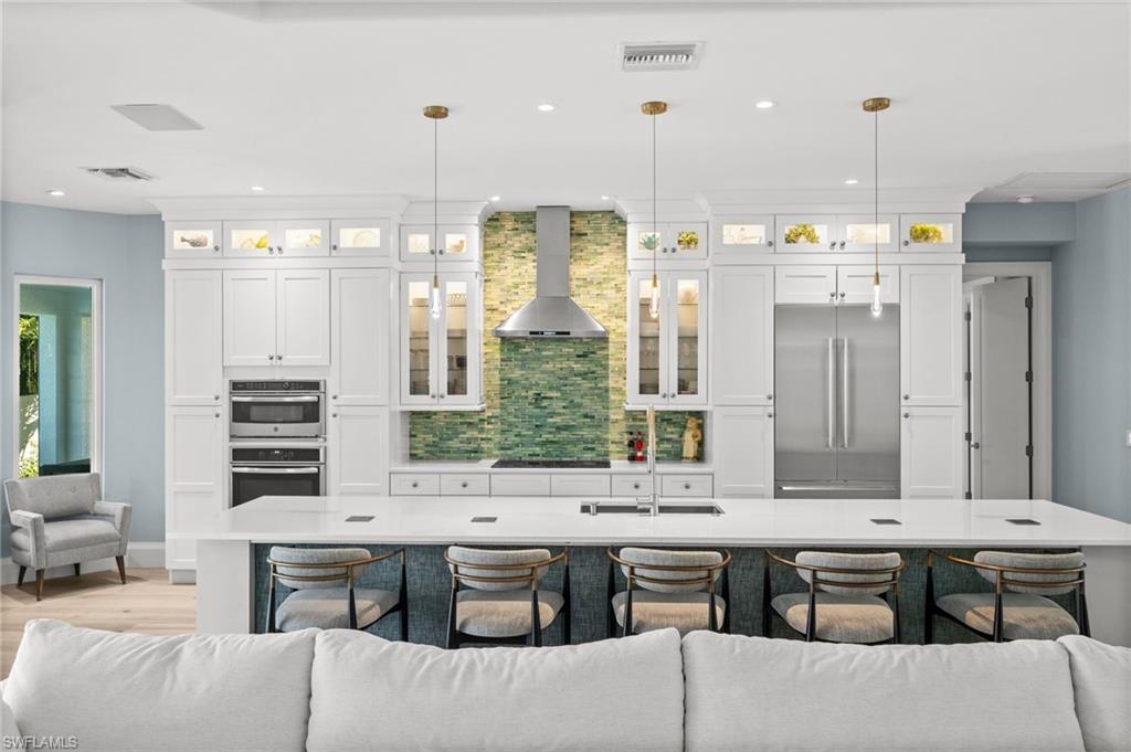 1963 Bethany Place Naples, FL 34109 - Photo 13 of 50 Thermador appliances, custom cabinetry, and a striking green tile accent wall create a showpiece kitchen for any home chef.