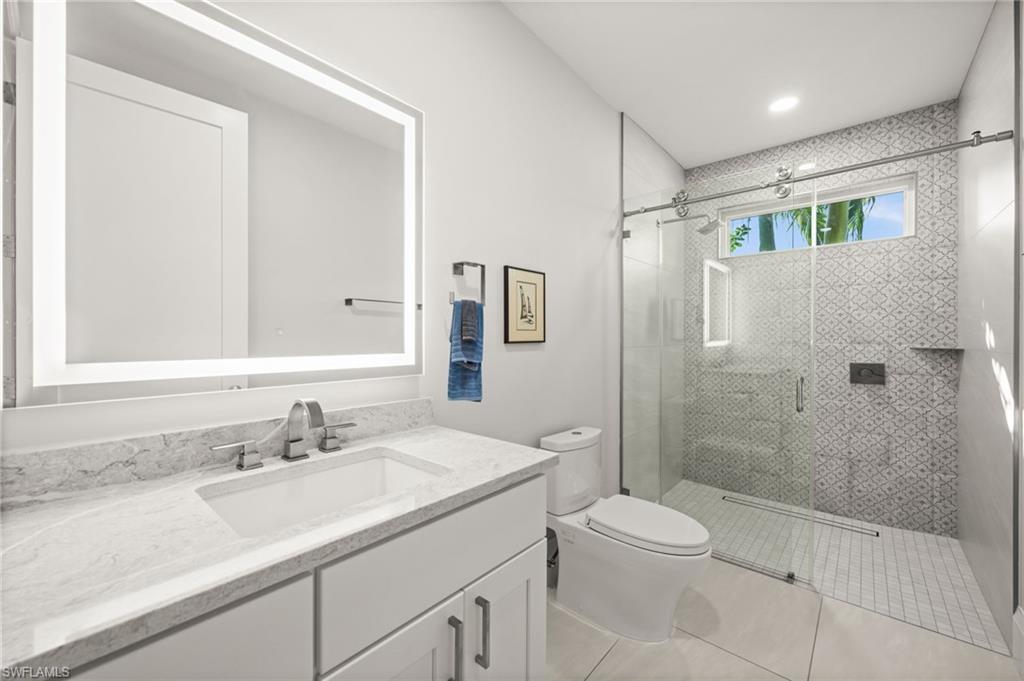 1963 Bethany Place Naples, FL 34109 - Photo 20 of 47 a bathroom with a sink a toilet and shower
