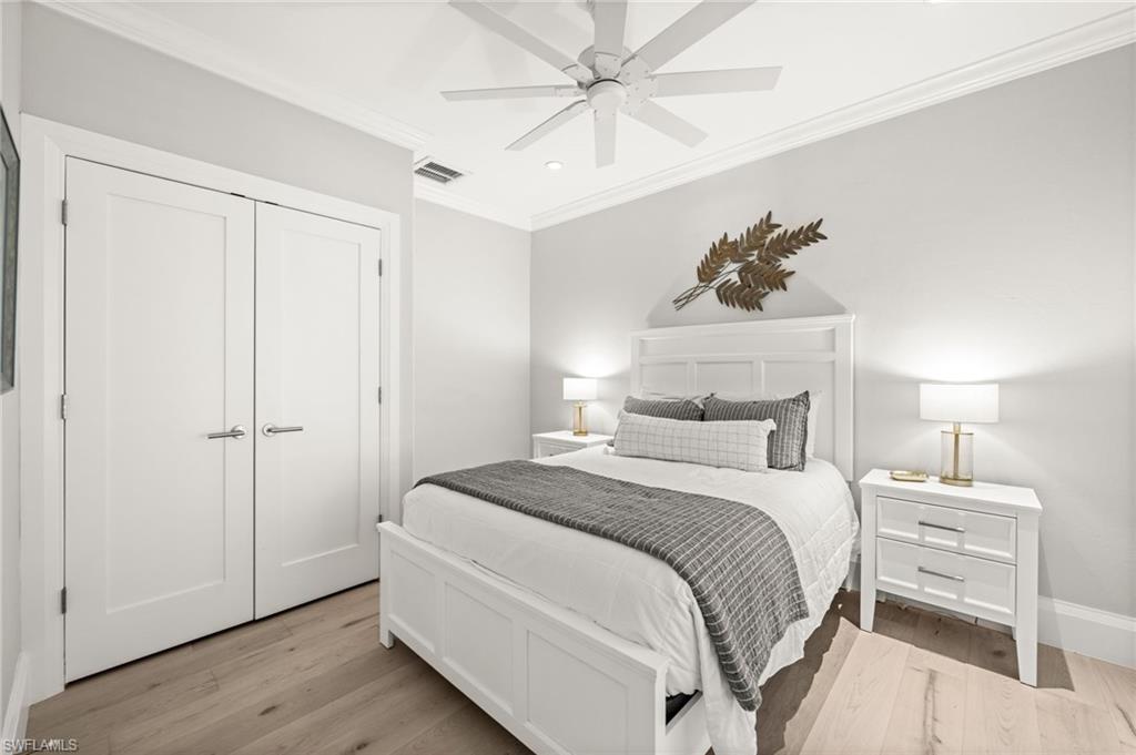 1963 Bethany Place Naples, FL 34109 - Photo 21 of 47 a bedroom with a bed and a chandelier