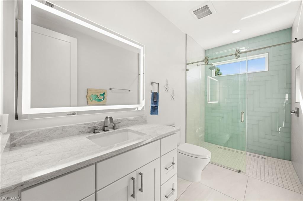 1963 Bethany Place Naples, FL 34109 - Photo 21 of 50 Bright white finishes paired with chic tile detailing for a spa-like feel.