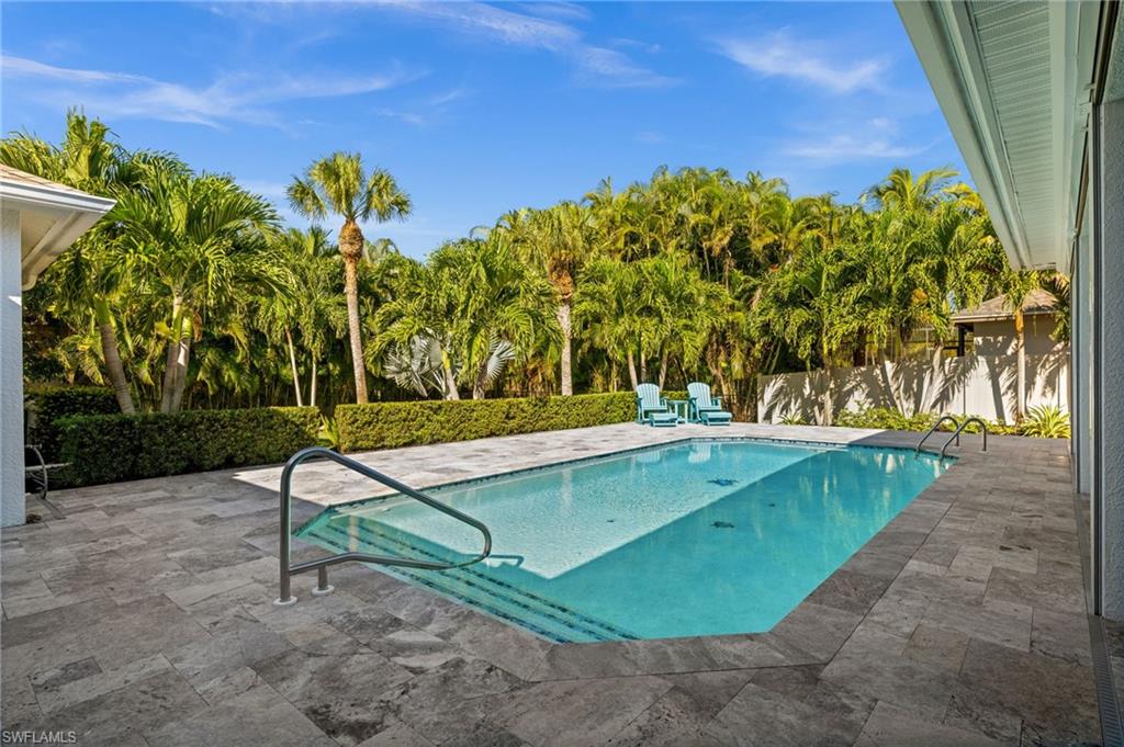 1963 Bethany Place Naples, FL 34109 - Photo 30 of 50 Enjoy a newly resurfaced pool surrounded by palm trees and abundant space for lounging or entertaining.