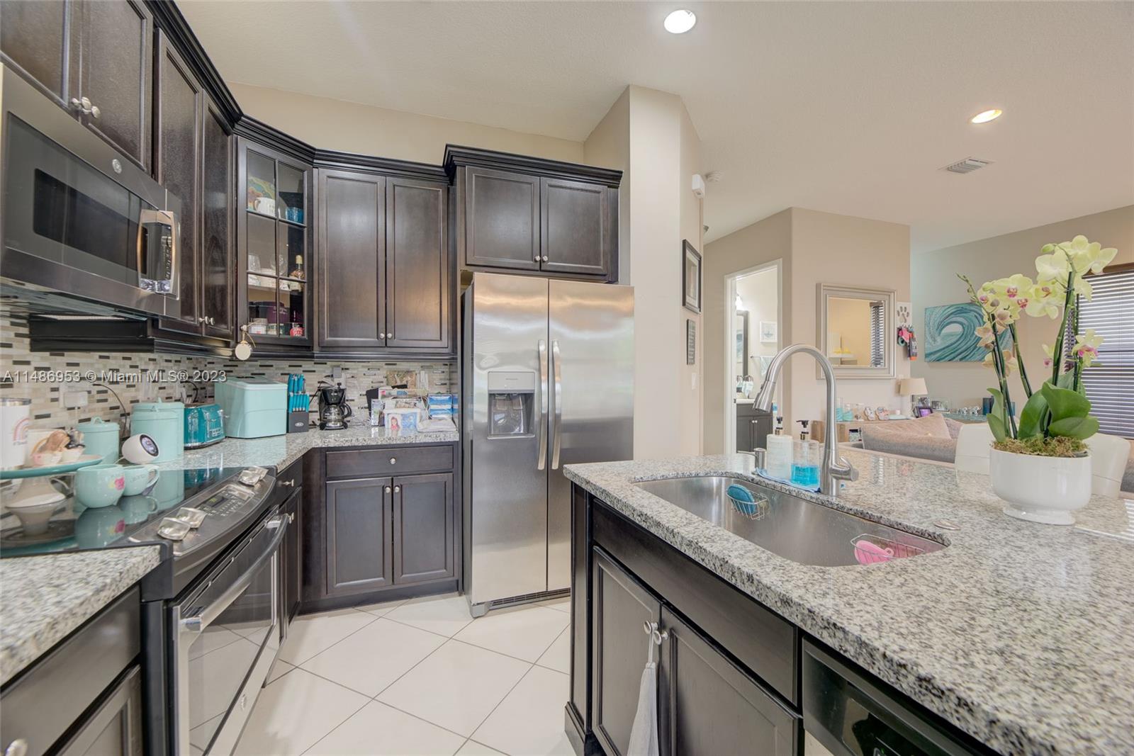 3308 West 95th Terrace Hialeah, FL 33018 - Photo 12 of 43 a kitchen with stainless steel appliances granite countertop a sink stove and refrigerator
