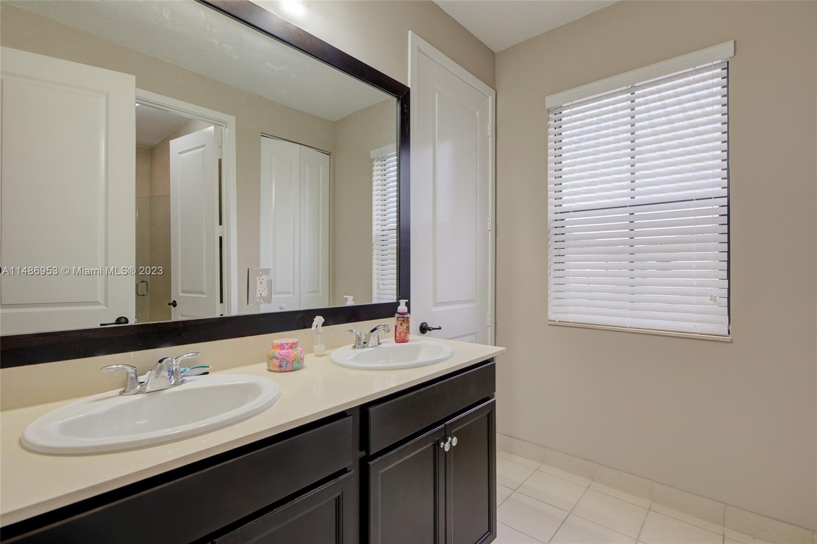 3308 West 95th Terrace Hialeah, FL 33018 - Photo 20 of 43 a bathroom with a double vanity sink and a mirror