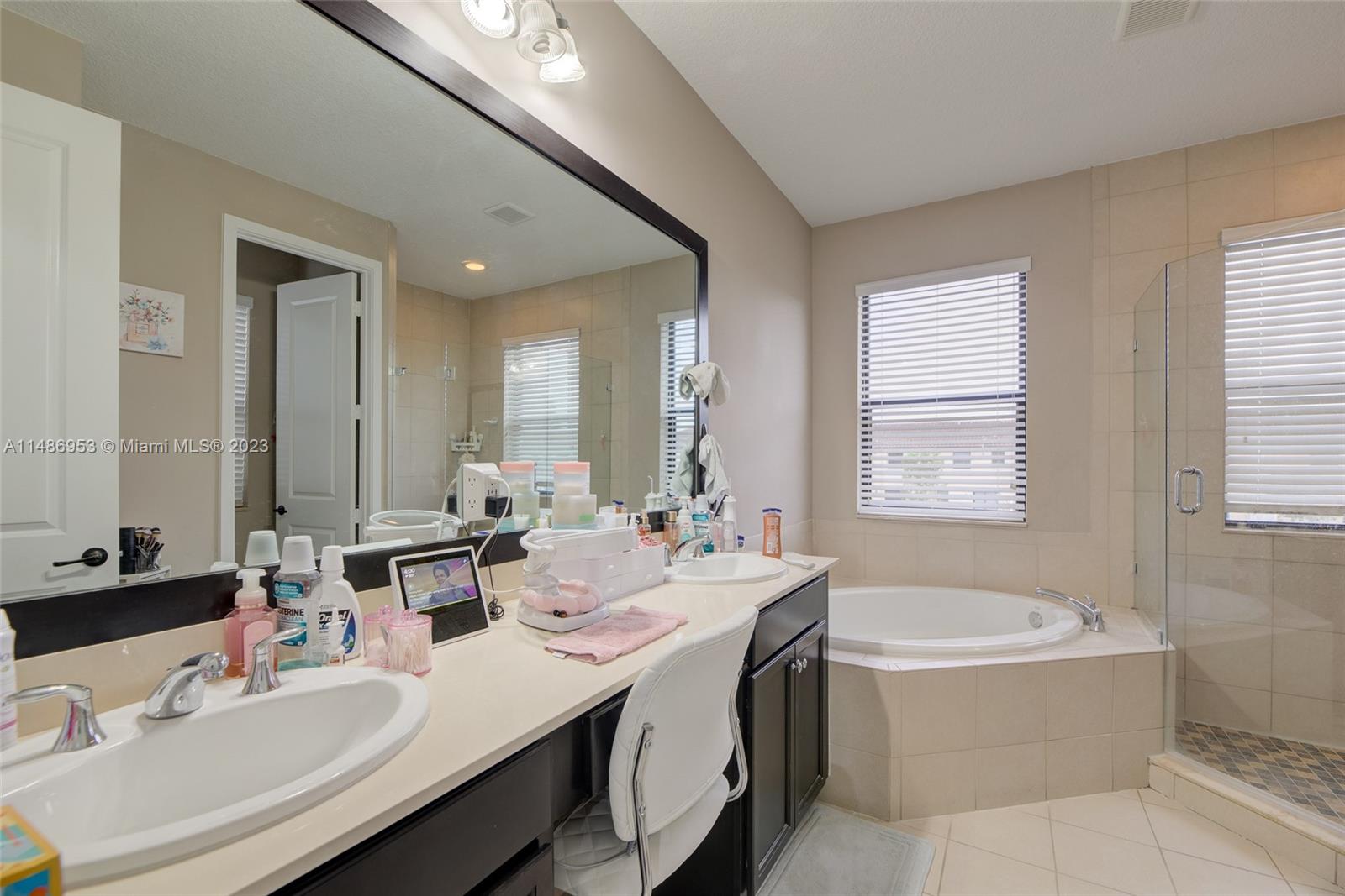 3308 West 95th Terrace Hialeah, FL 33018 - Photo 29 of 43 a bathroom with a tub double sink window and mirror