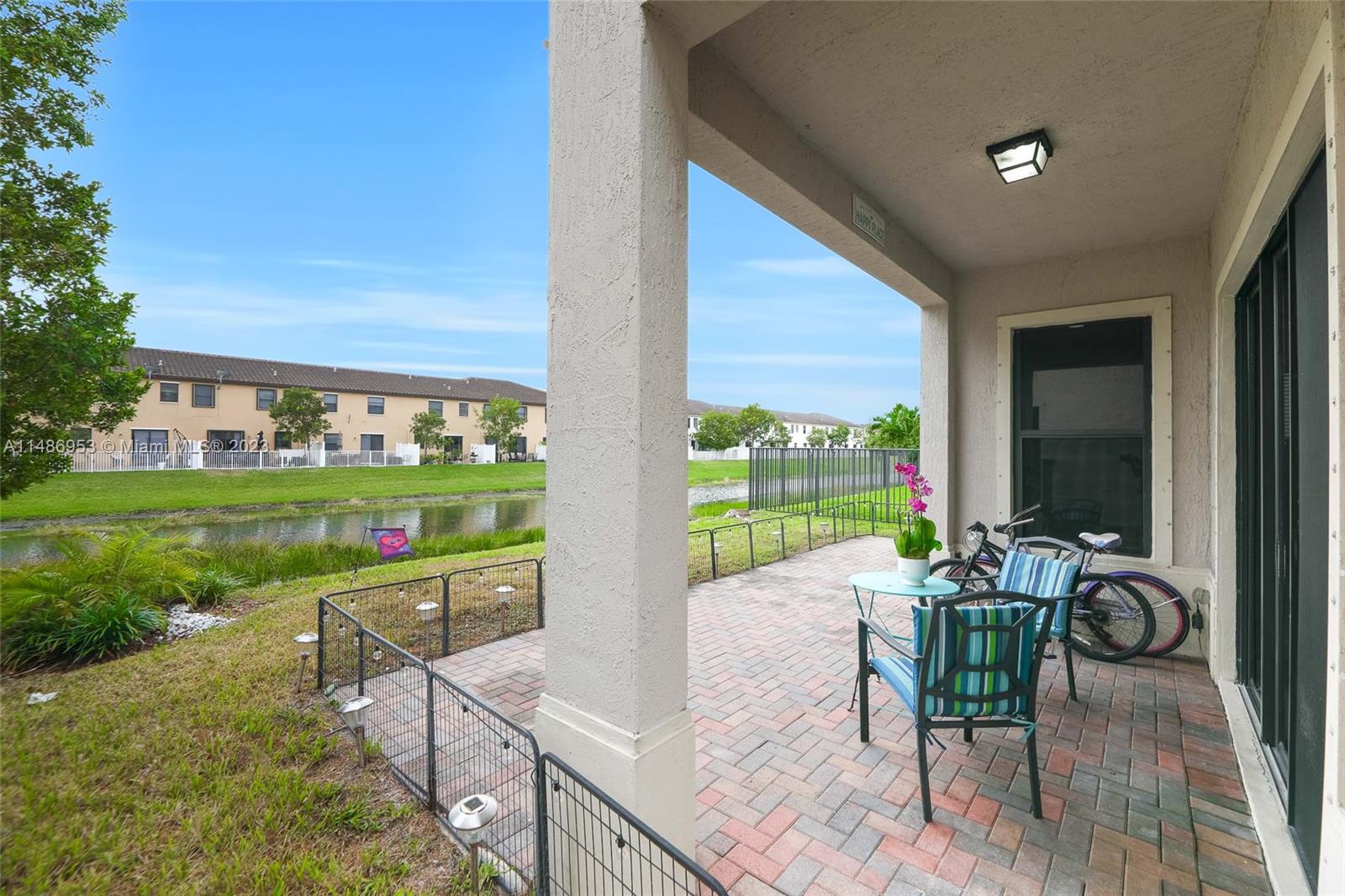 3308 West 95th Terrace Hialeah, FL 33018 - Photo 32 of 43 a view of a patio with table and chairs potted plants with wooden floor and fence