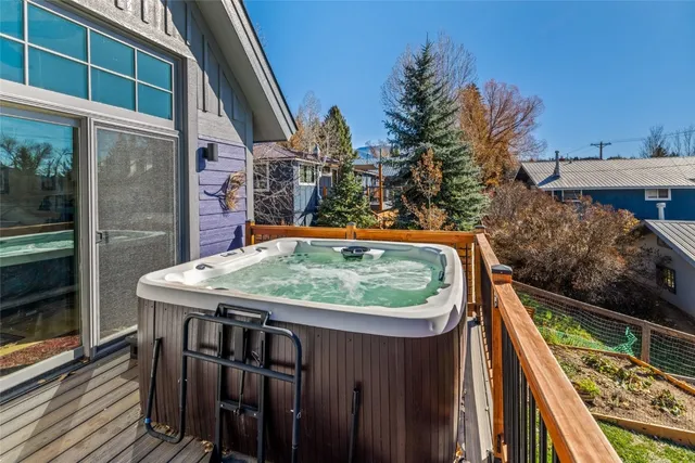 a balcony with wooden floor table and outdoor seating