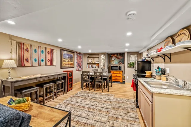 a living room with stainless steel appliances furniture stove and kitchen view