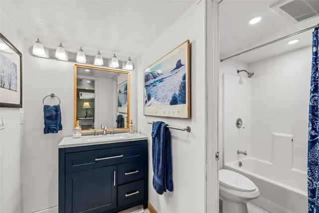 a bathroom with a toilet a sink and a large mirror