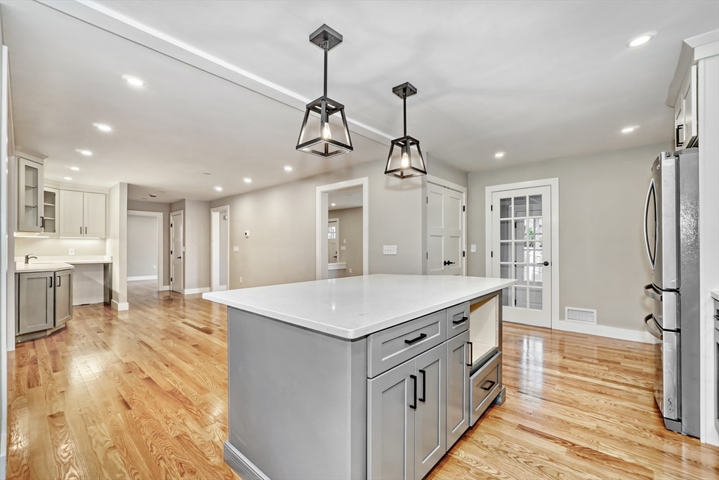 111 Cedar Street Lexington, MA 02421 - Photo 6 of 40 a large kitchen with kitchen island a stove a sink a refrigerator and a view of living room