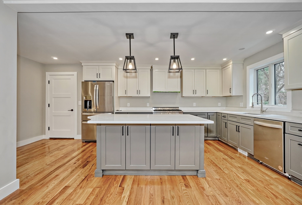 111 Cedar Street Lexington, MA 02421 - Photo 8 of 40 a large kitchen with cabinets wooden floor and stainless steel appliances