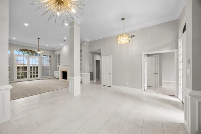 a view of an empty room with a window and kitchen view