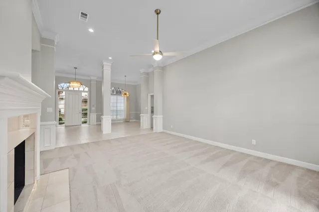 a view of empty room with fireplace and fan