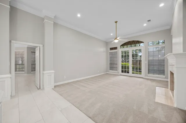 a view of an empty room with a window and chandelier