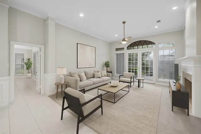 a living room with furniture a fireplace and a chandelier