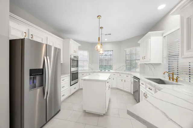 a kitchen with a refrigerator sink and cabinets