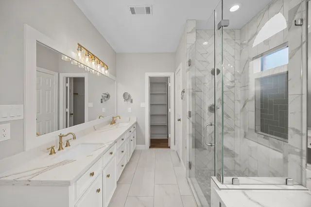 a bathroom with a double vanity sink mirror and shower