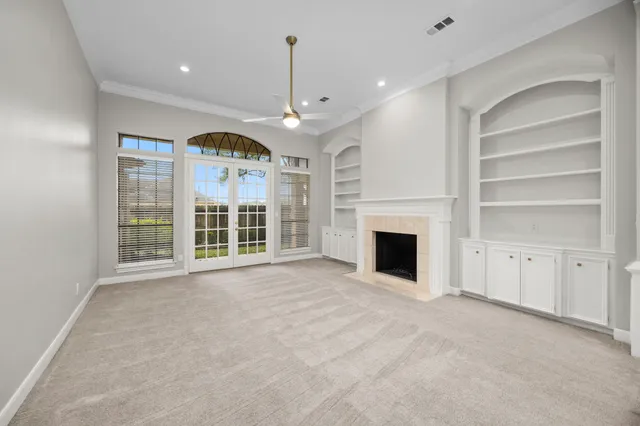 a view of an empty room with a fireplace and a window
