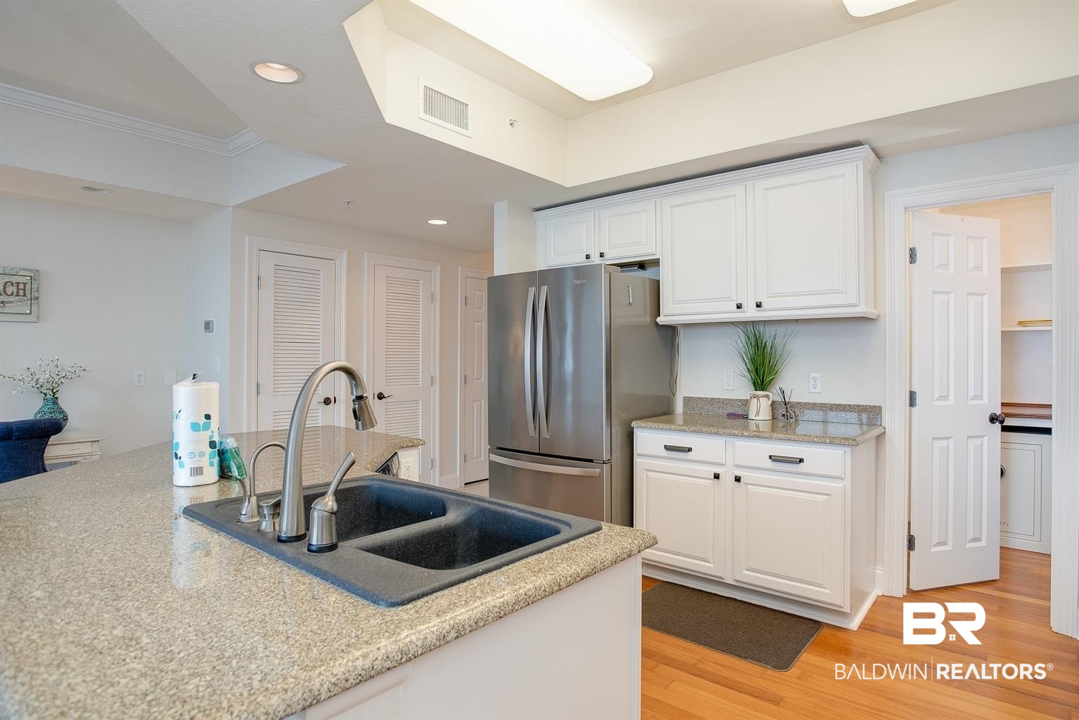 27800 Canal Road, Unit 411 Orange Beach, AL 36561 - Photo 8 of 49 Kitchen showcasing light-toned countertops, white cabinetry, and stainless steel appliances