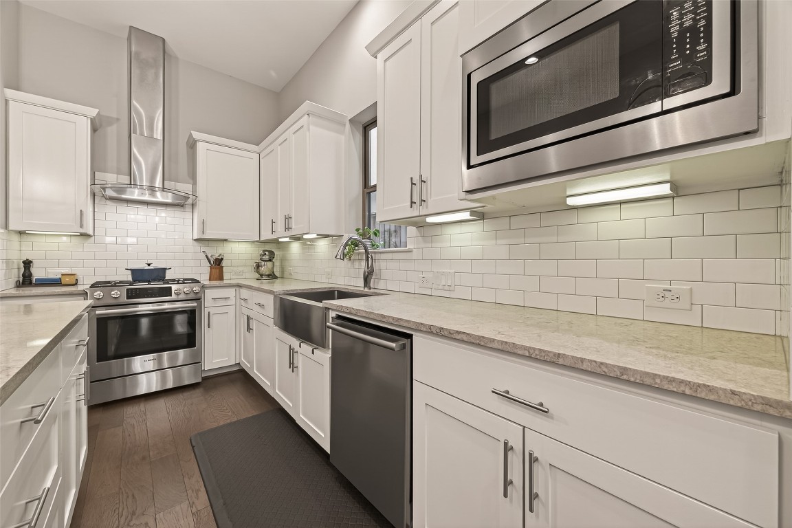 604 West Pierce Street Houston, TX 77019 - Photo 12 of 33 a kitchen with stainless steel appliances granite countertop white cabinets a sink a stove and a microwave