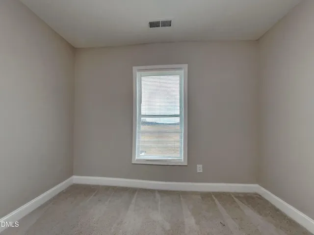 an empty room with closet and a bathroom