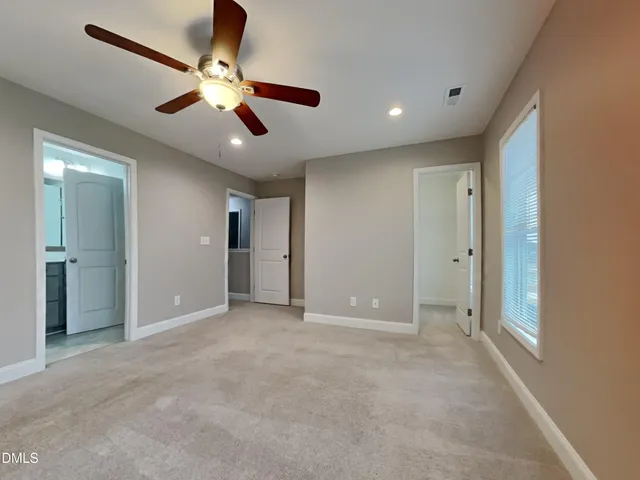an empty room with closet and a chandelier fan