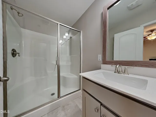 a bathroom with a shower sink and mirror