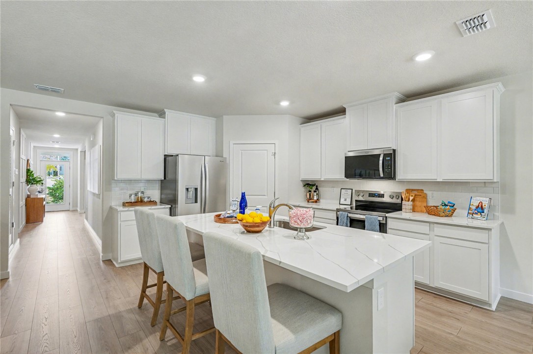 793 George Street Sebastian, FL 32958 - Photo 10 of 22 a kitchen with stainless steel appliances a stove a sink a refrigerator cabinets and a dining table