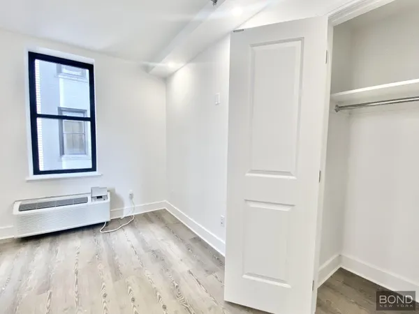 an empty room with windows and closet