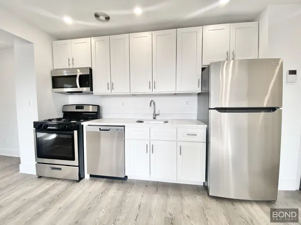a kitchen with stainless steel appliances a refrigerator sink and cabinets