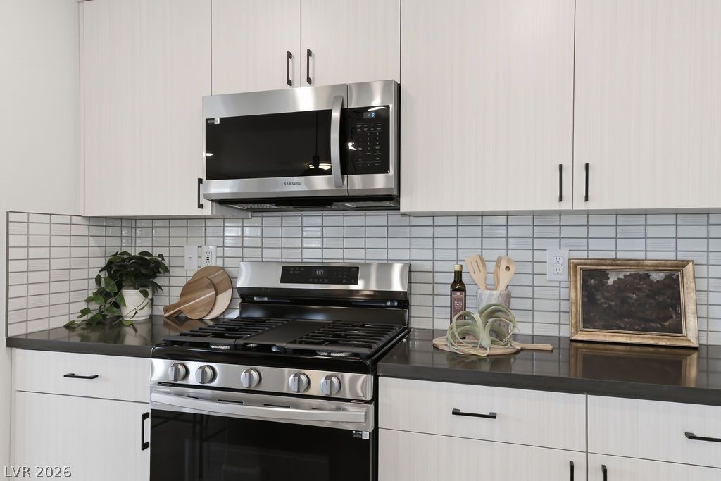 913 Cadence View Way Henderson, NV 89011 - Photo 19 of 46 A contemporary kitchen features stainless steel appliances and crisp white cabinetry, perfect for modern living.