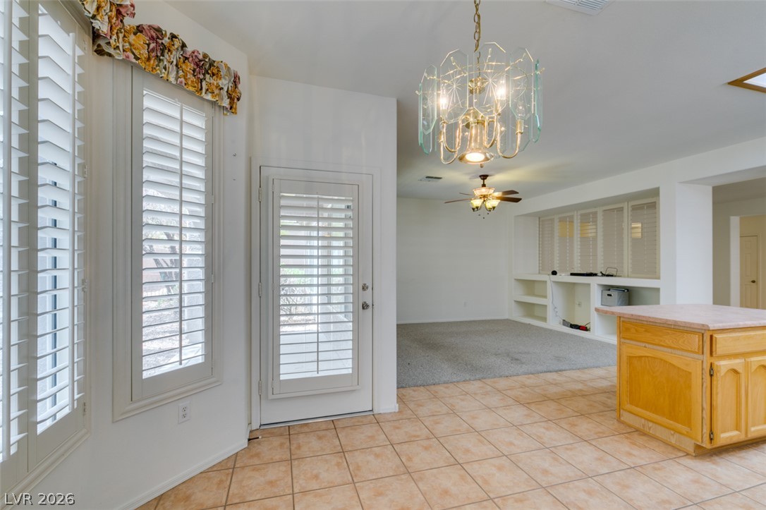 2189 Chapman Ranch Drive Henderson, NV 89012 - Photo 25 of 60 Tiled flooring and tall windows with plantation shutters flow into the adjacent carpeted living area.