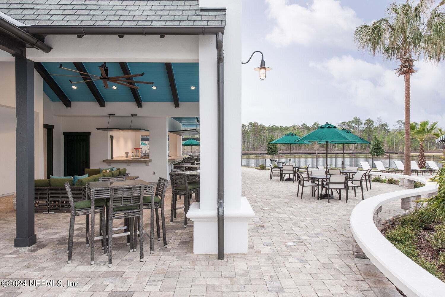 58 Martello Drive St. Augustine, FL 32092 - Photo 25 of 26 a view of a patio with table and chairs potted plants and palm tree