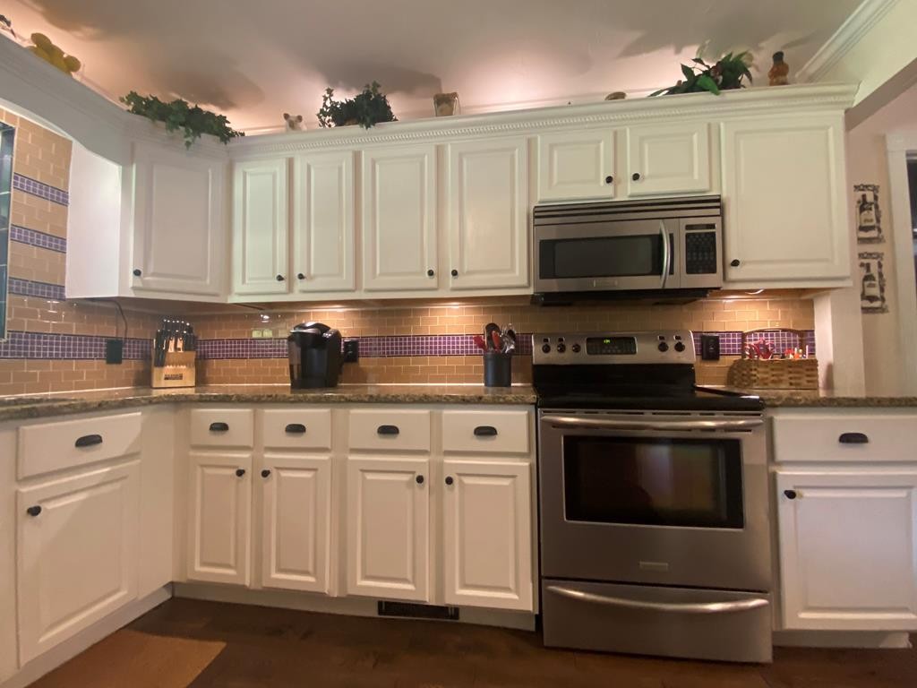 1129 Red Hill Valley Road Southeast Cleveland, TN 37323 - Photo 17 of 35 a kitchen with stainless steel appliances granite countertop a stove a sink and a microwave