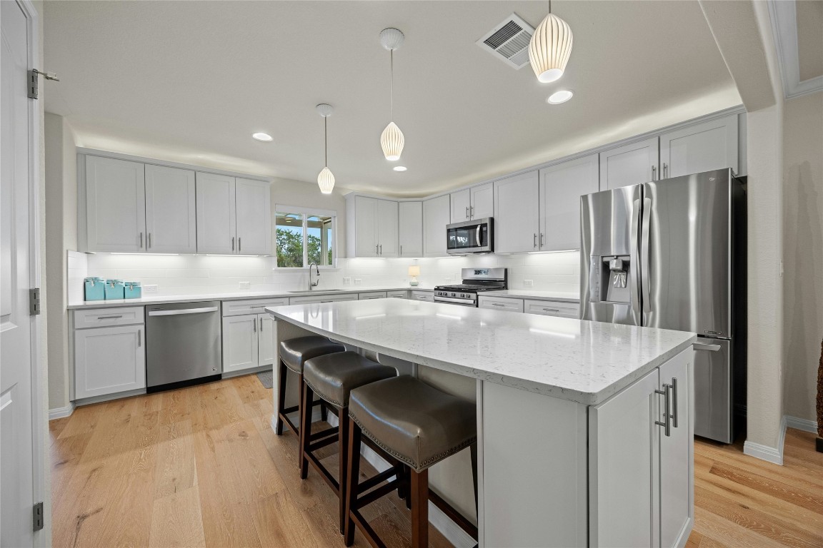 a kitchen with granite countertop a sink cabinets and stainless steel appliances
