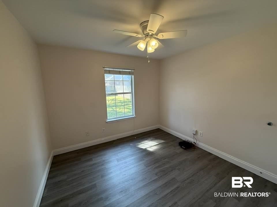 10428 South Side Loop Fairhope, AL 36532 - Photo 24 of 28 Spare room featuring ceiling fan, dark wood finished floors, and baseboards