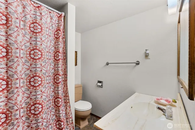 a backyard of a house with plants and large tree