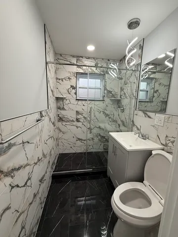 a bathroom with a toilet and a shower
